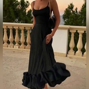 Black Flared Spaghetti Strap Dress With Ruffle Hem On Bottom.